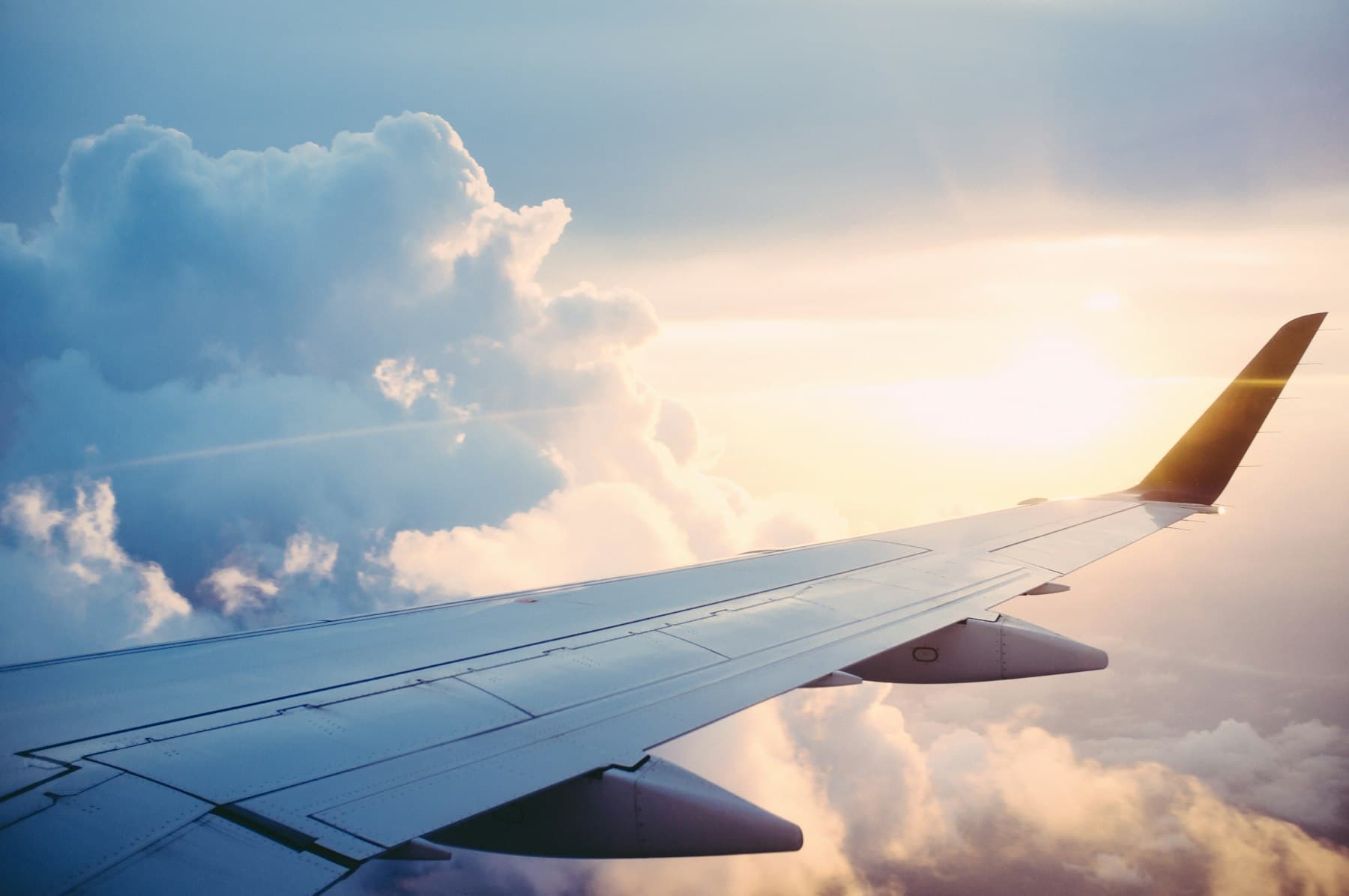Airplane wing above the clouds, for a Montreal limousine transfer at Montréal-Trudeau (YUL)