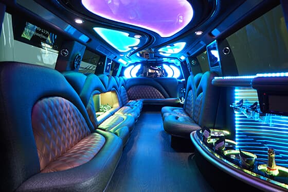 Stretch SUV cabin with white leather bench seats