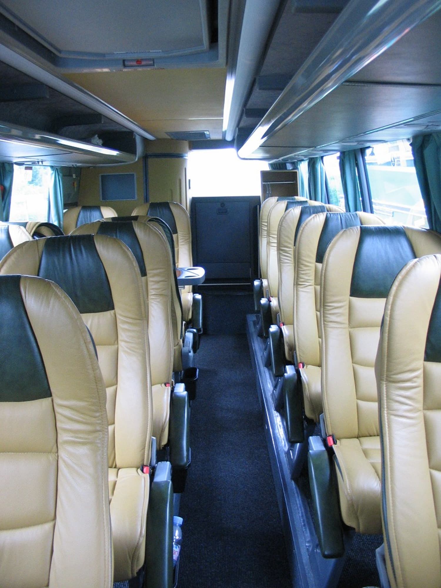 Large coach bus cabin looking forward along the center aisle