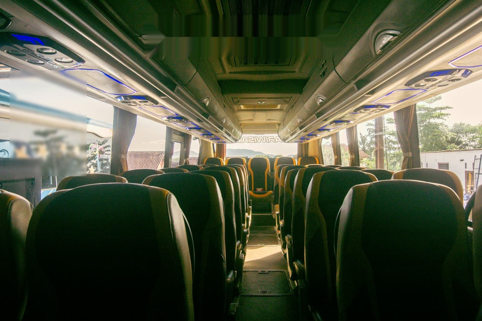 Mid-size coach bus cabin with rows of seats and a center aisle